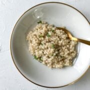 Easy Israeli Couscous with Parmesan on a white plate on a white table