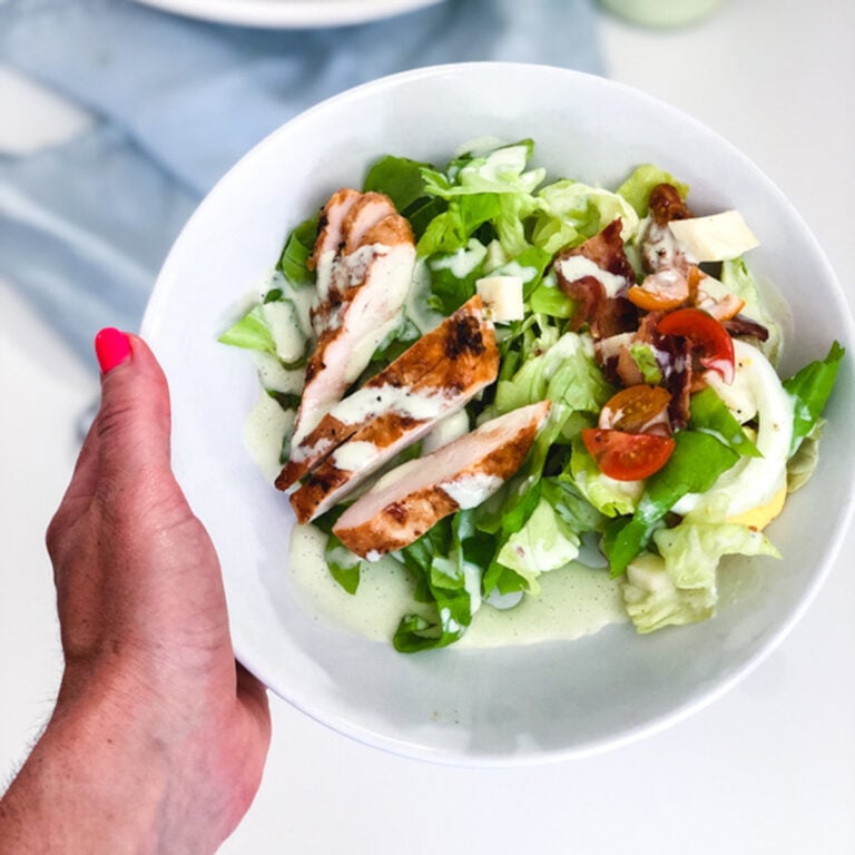 holding a plate of BBQ Chicken Cobb Salad with Herb Yogurt Dressing