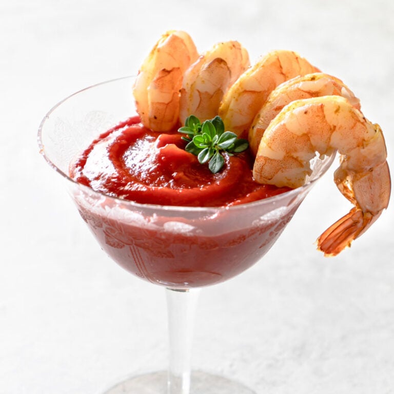 platter of sous vide shrimp cocktail with lemon edges and cocktail sauce