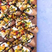 Corn Peach & Jalapeno Salsa on a cutting board and blue background