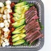 Sous Vide Flank Steak Salad in a silver bowl on a white table showing 3/4 off t