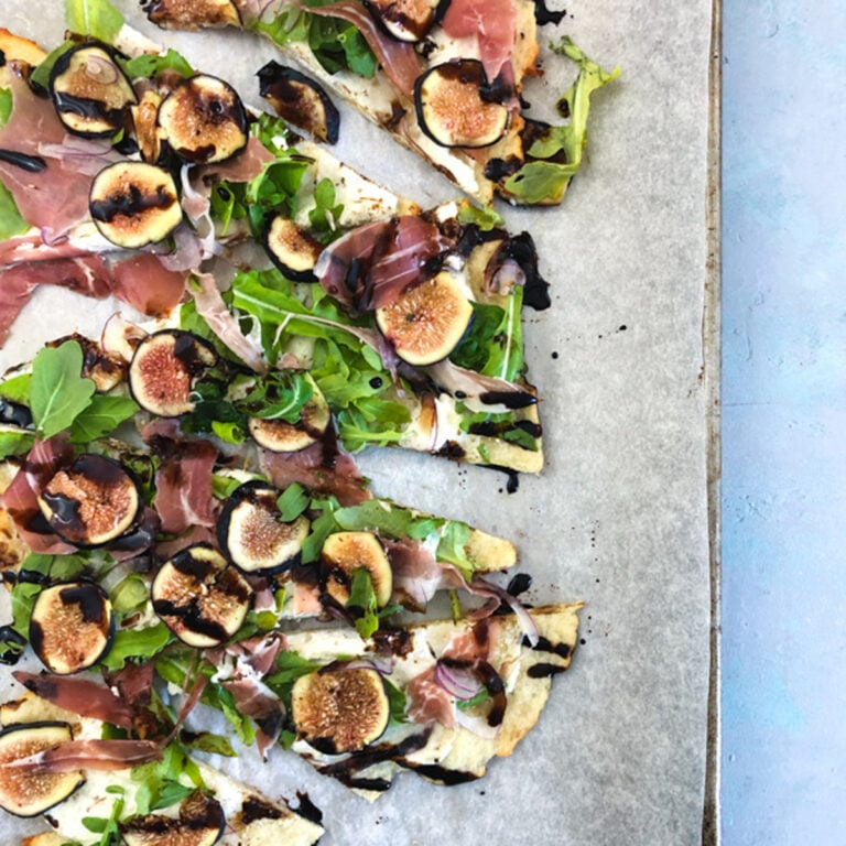 Ricotta Fig Prosciutto Pizza on a baking sheet and white plates