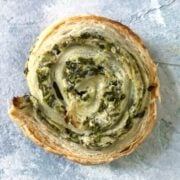 Spinach and Artichoke Puff Pastry Swirl on a blue background