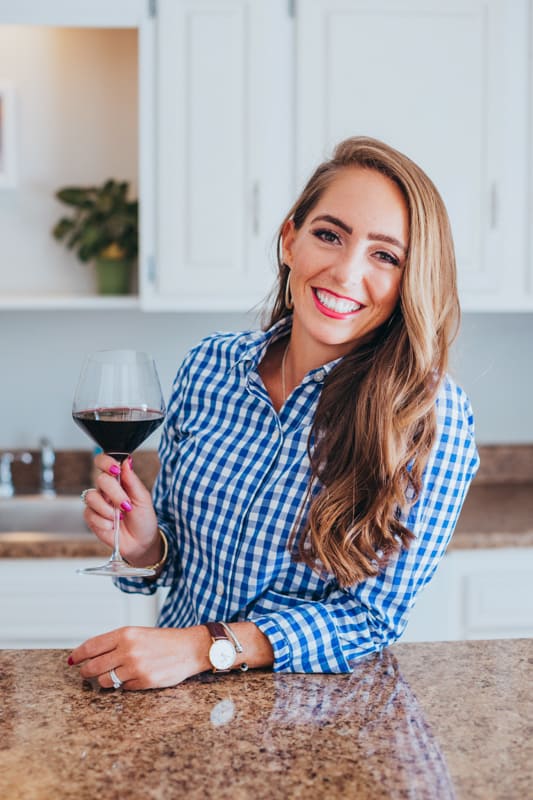 me holding a glass of wine in the kitchen