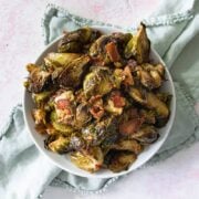 sweet chili brussel sprouts in a big bowl with a green napkin under the bowl