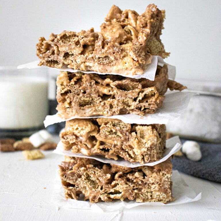 stacked Chocolate Chex Marshmallow Bars with the pan and a glass of milk