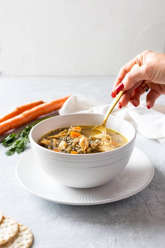 a hand eating scooping out a bite of turkey and rice soup