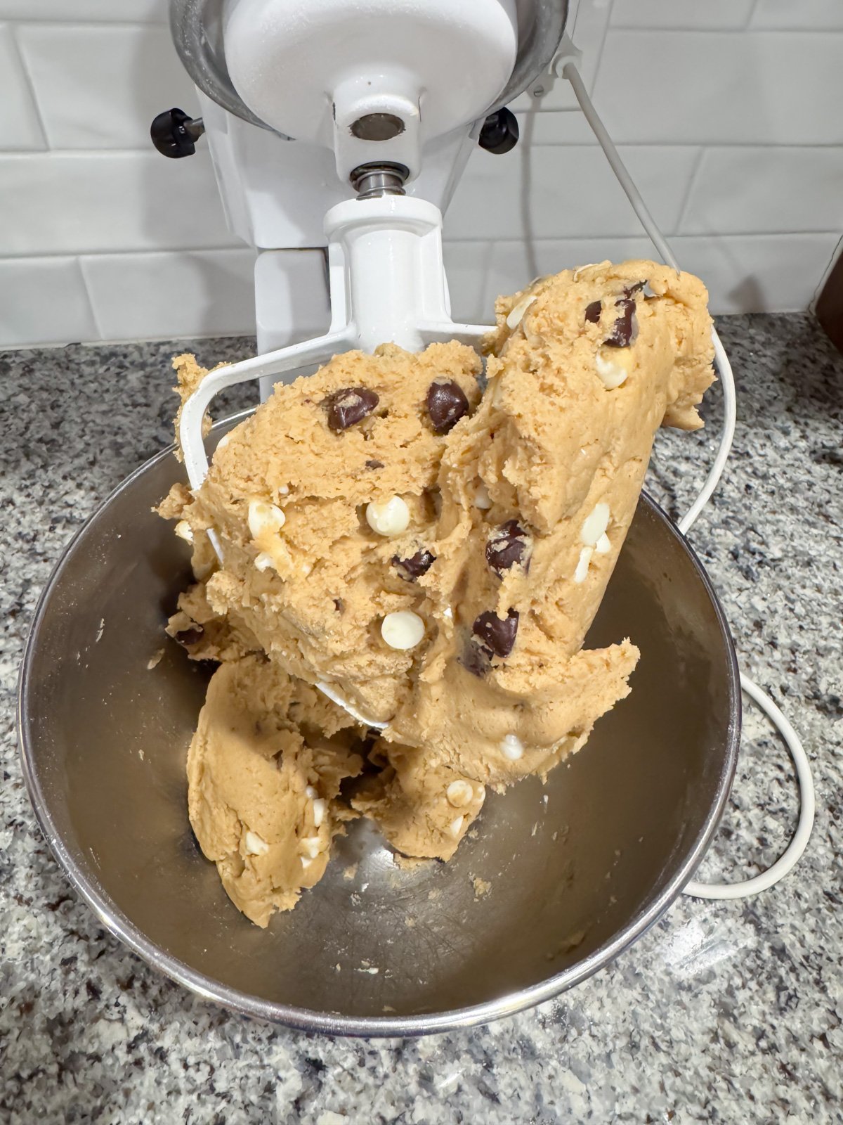 Cookie dough in a stand mixer on the paddle. 