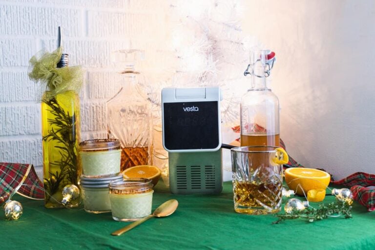 homemade christams gifts made with the sous vide. olive oil infusion, bourbon drink,and creme brulee. with a white christmas tree in the background.