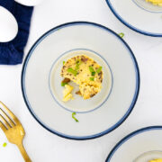 sous vide bacon and cheddar egg bite on a blue plate with a gold fork next to the plate