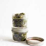 2 mason jars of diced green chilies on a white table
