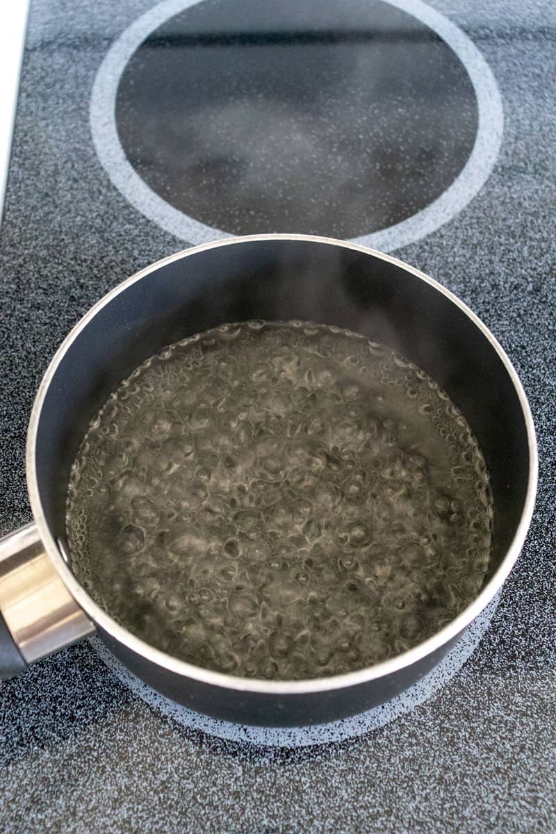 black pot on the stove boiling sugar and water together