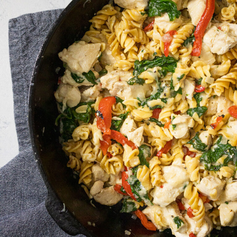 chicken and spinach pasta in a cast iron skillet