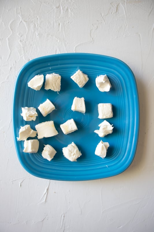 Cream cheese chunks on a blue plate.