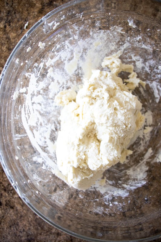 Mixing together greek yogurt pizza dough in a bowl.