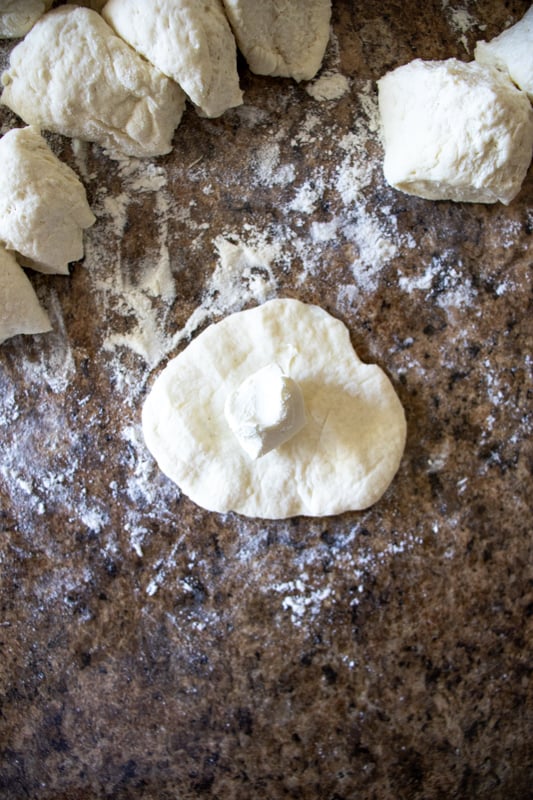 A small cream cheese cube in the middle of pizza dough.