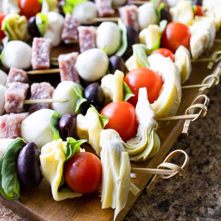 Easy Antipasto Skewers lined up on a cutting board.
