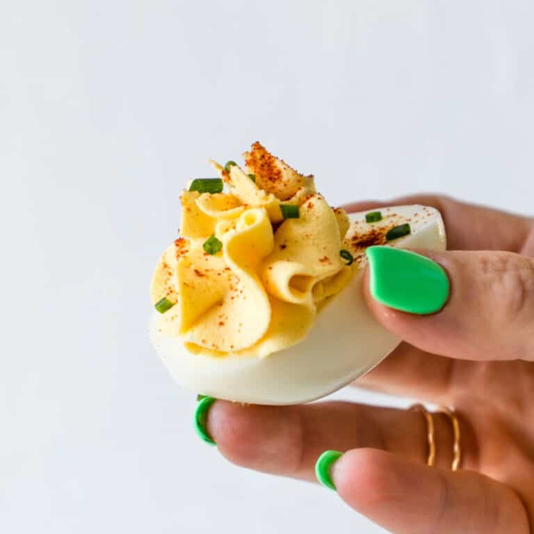 Hand holding a deviled egg.