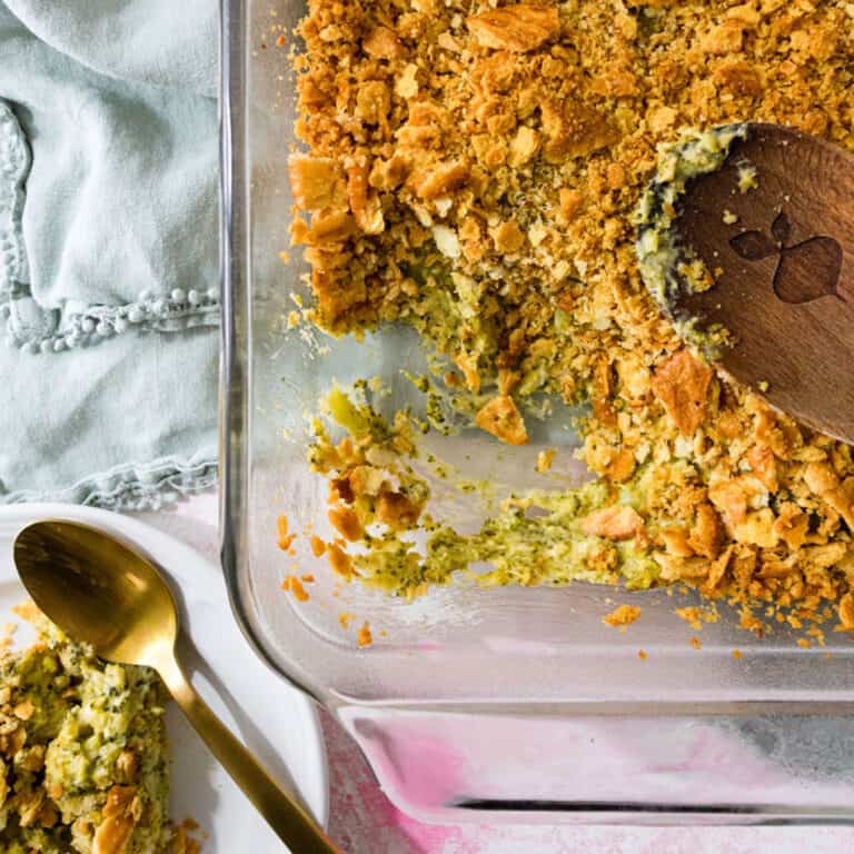 A scoop taken out of a dish of broccoli casserole.