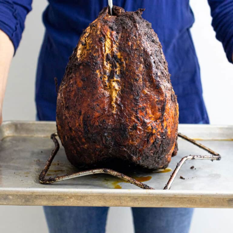 me holding a fried turkey on a baking sheet.