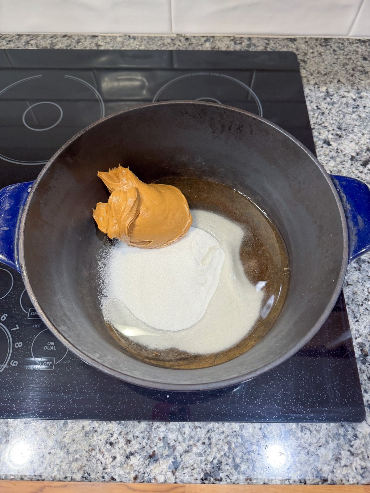 peanut butter, sugar, and corn syrup in a pot on the stove.