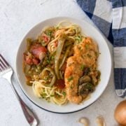 Easy Dutch Oven Chicken Cacciatore in a white bowl with blue checkered napkin next to it