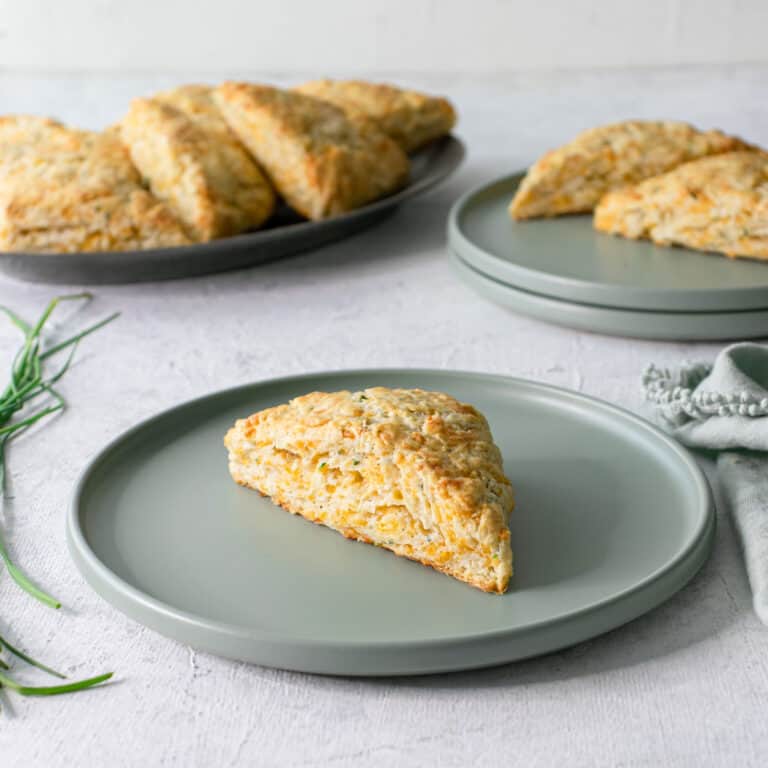 Cheddar chove scones on green plates.
