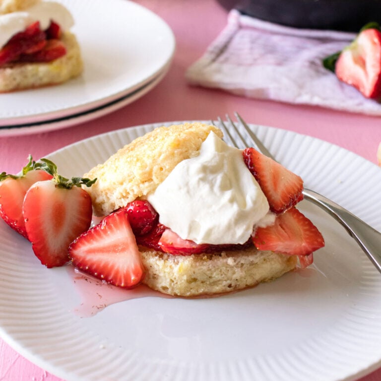 Sweet and Tender Strawberry Shortcake Biscuits assembled on a white a white plate.