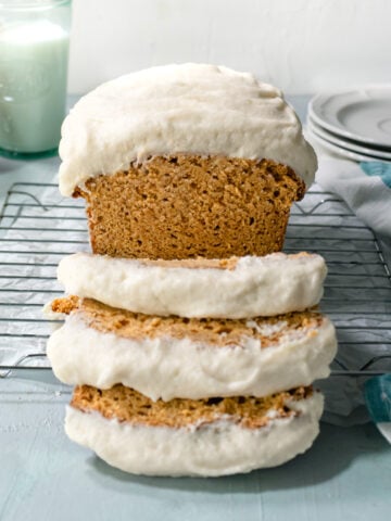 Sweet potato bread with frosting sliced in 3 pieces with milk in the background.