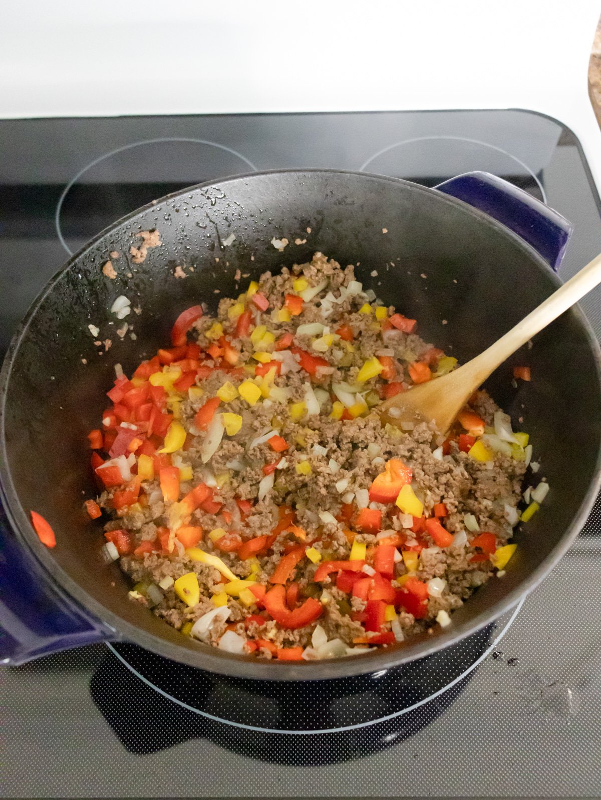 Sautéing onions and peppers in a big pot on the stove.