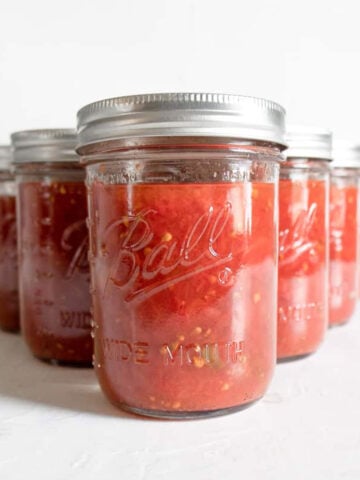 mason jars on a white table for How to Can Tomatoes