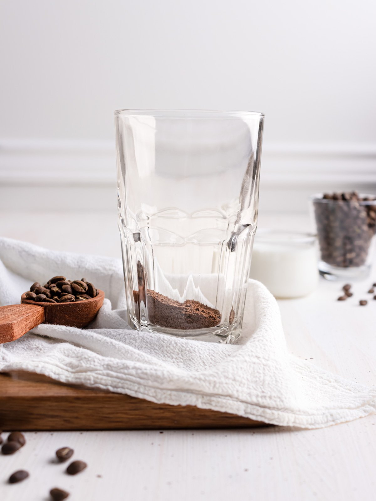 a clear drinking glass with instant coffee inside.