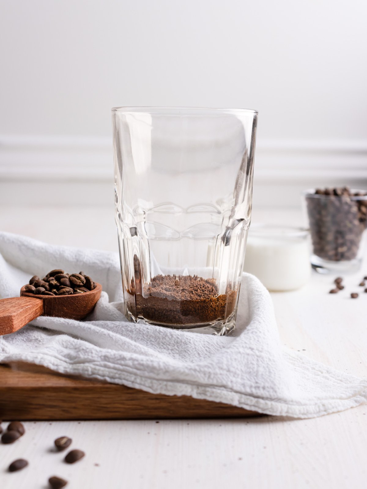 instant coffee powder and a little water inside a clear drinking glass.
