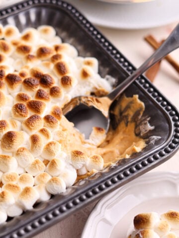 sweet potato dessert dip with mini marshmallows on top and a spoon inside.