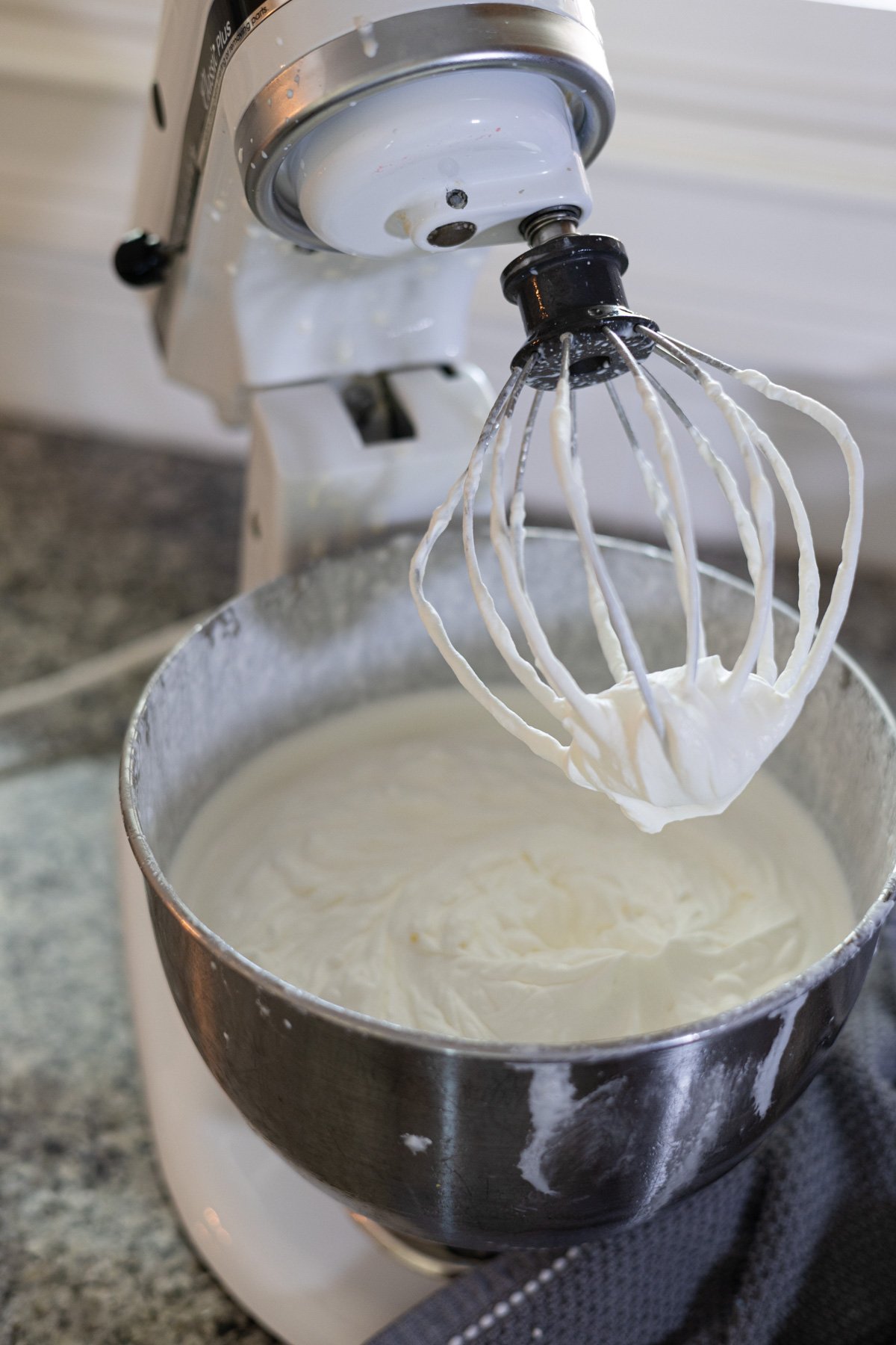 making whipped cream in a stand mixer on a kitchen counter. 