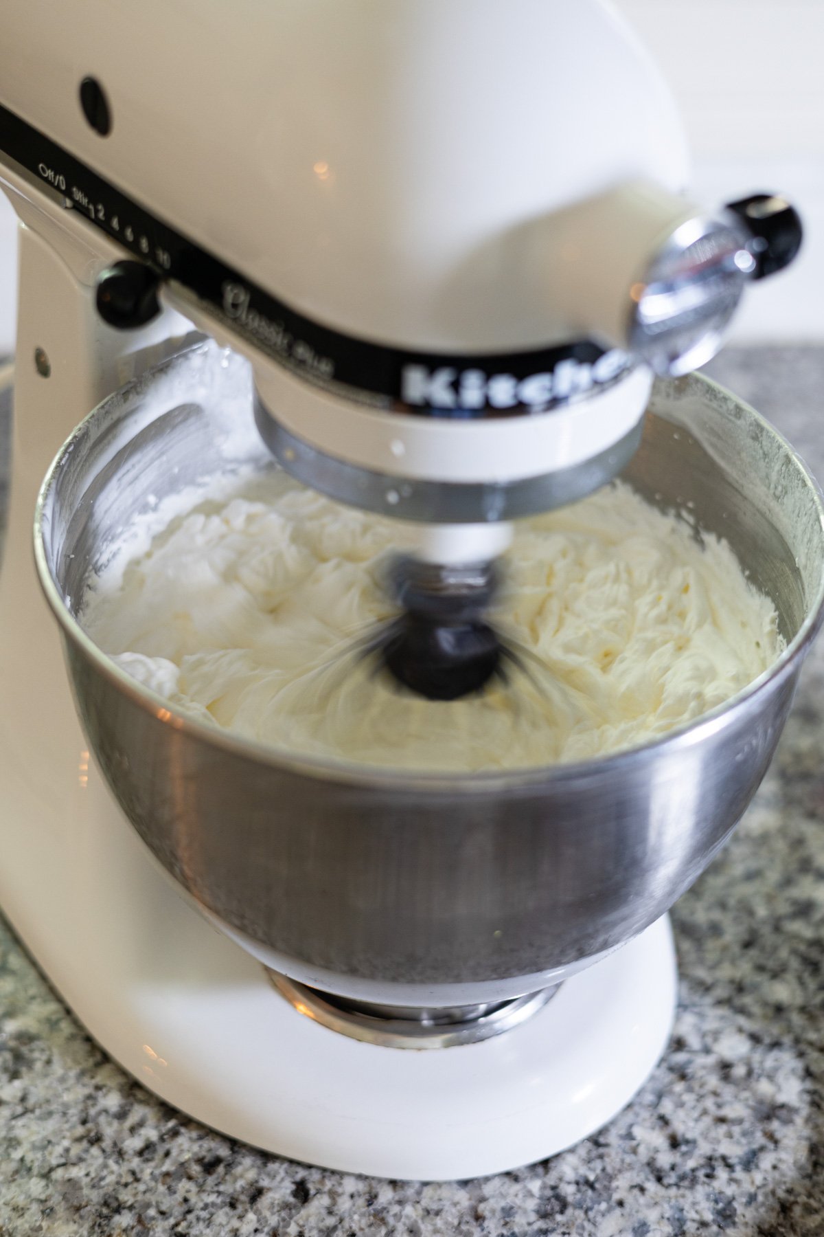 mixing whipped cream in a stand mixer. 