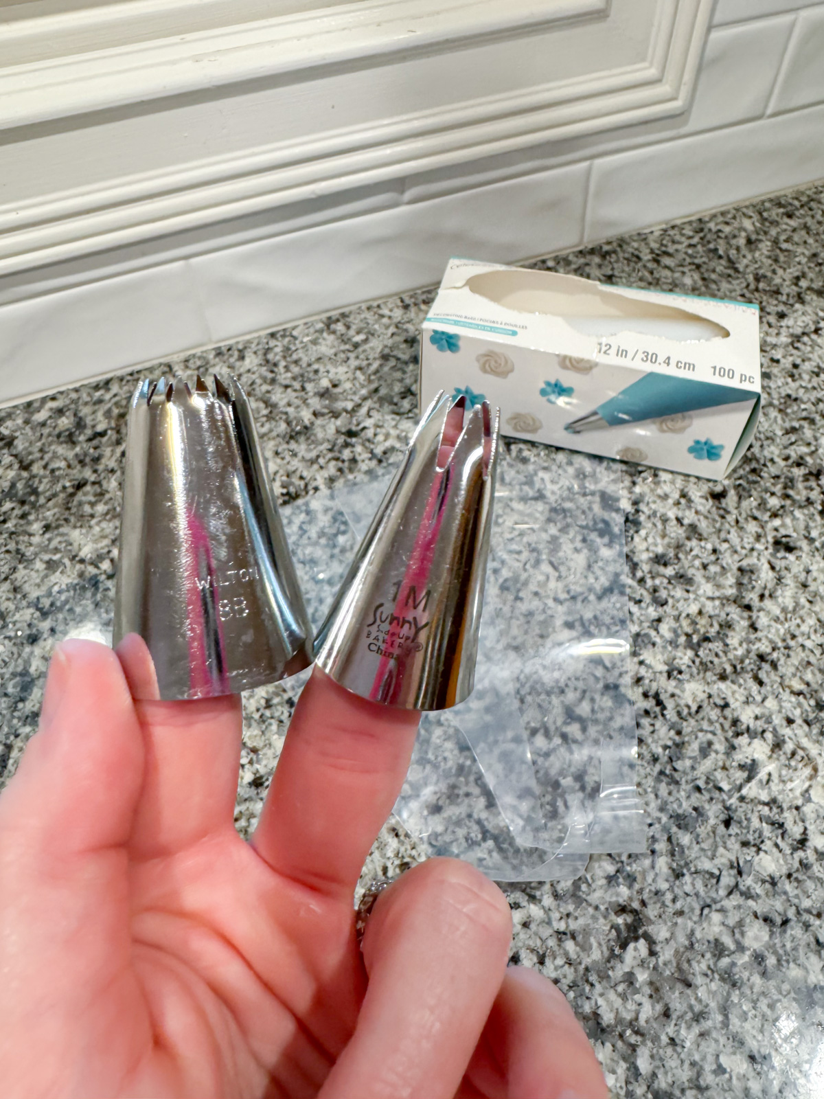 a hand holding piping tips,