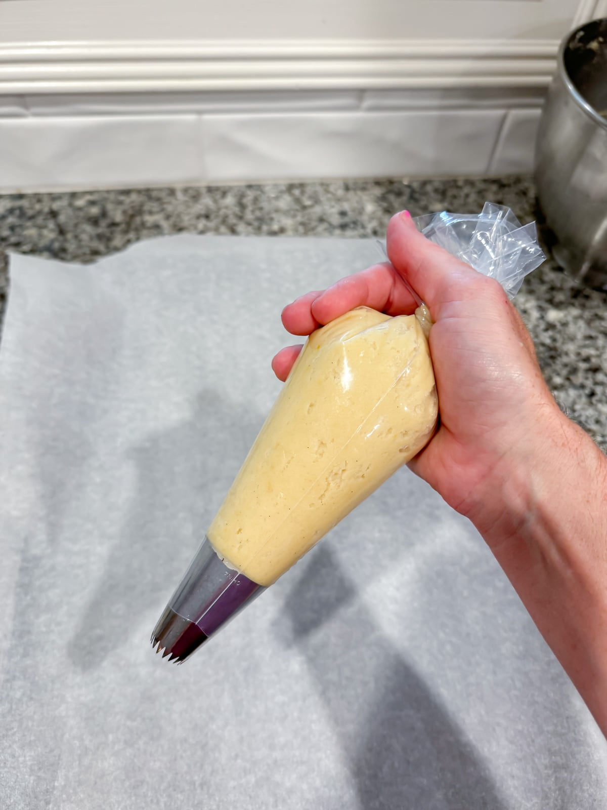 a hand holding a piping bag of cookie dough.