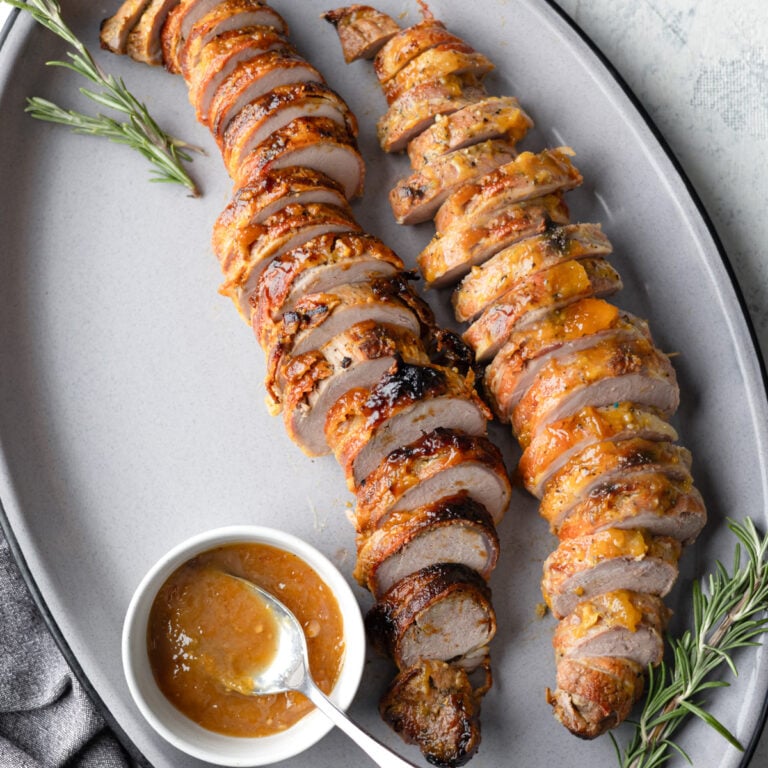 pork tenderloin sliced and payed out on a platter.