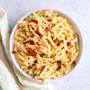 bacon Mac and cheese in a large serving bowl with a napkin next to it.