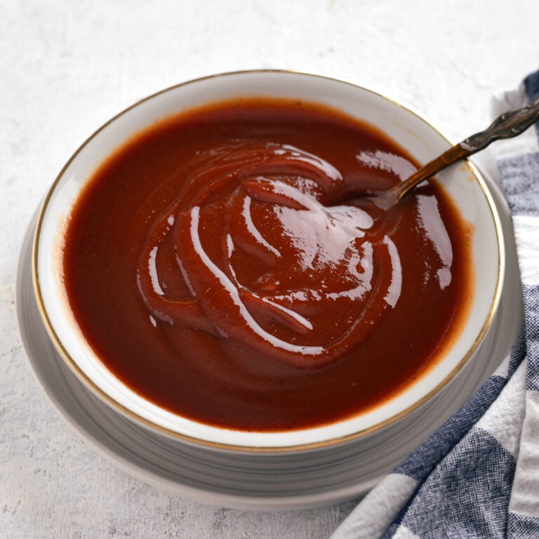 bourbon BBQ sauce in a shallow bowl with a spoon in it.