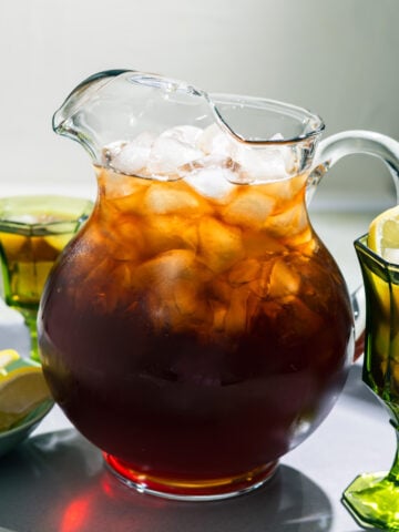 pitcher of sweet tea with 2 glasses in the background
