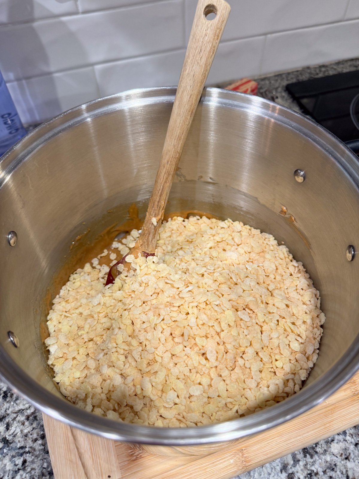 Stir in Rice Krispies into a peanut butter sugar mixture in a large pot.