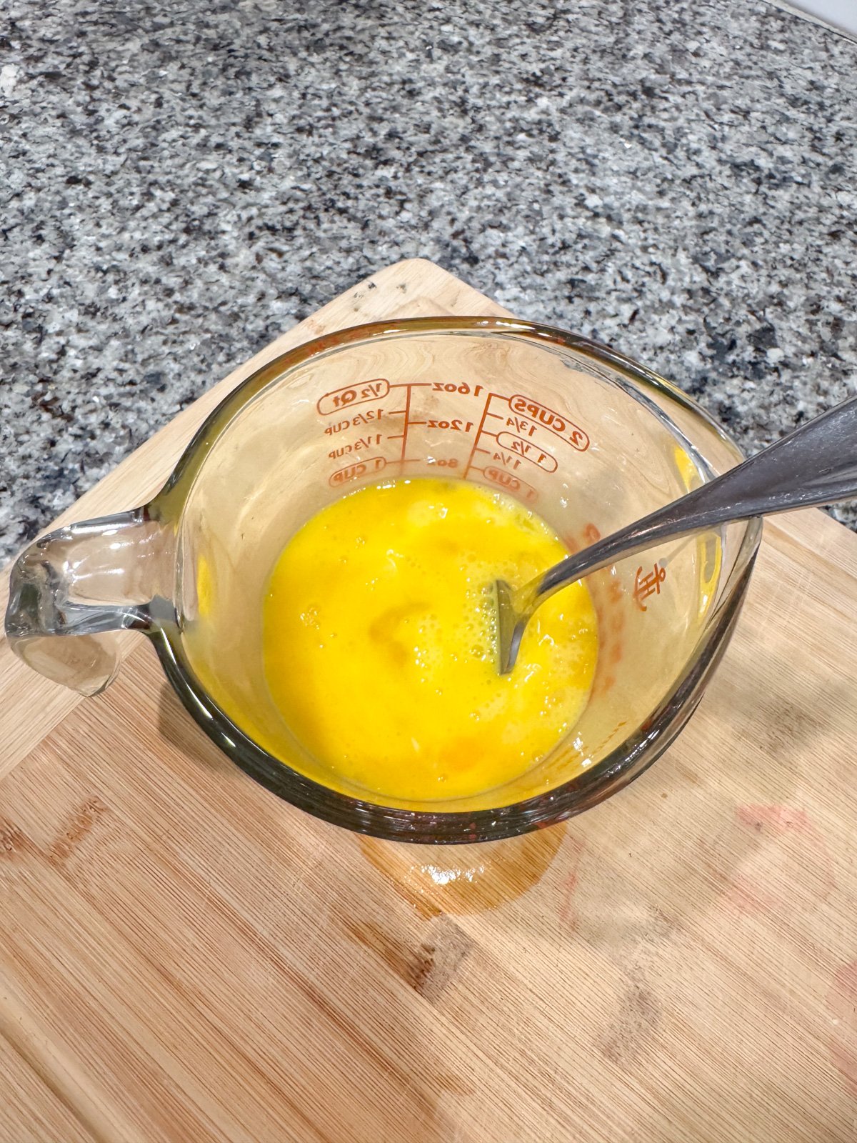 whisking eggs in a pyrex dish with a fork. 