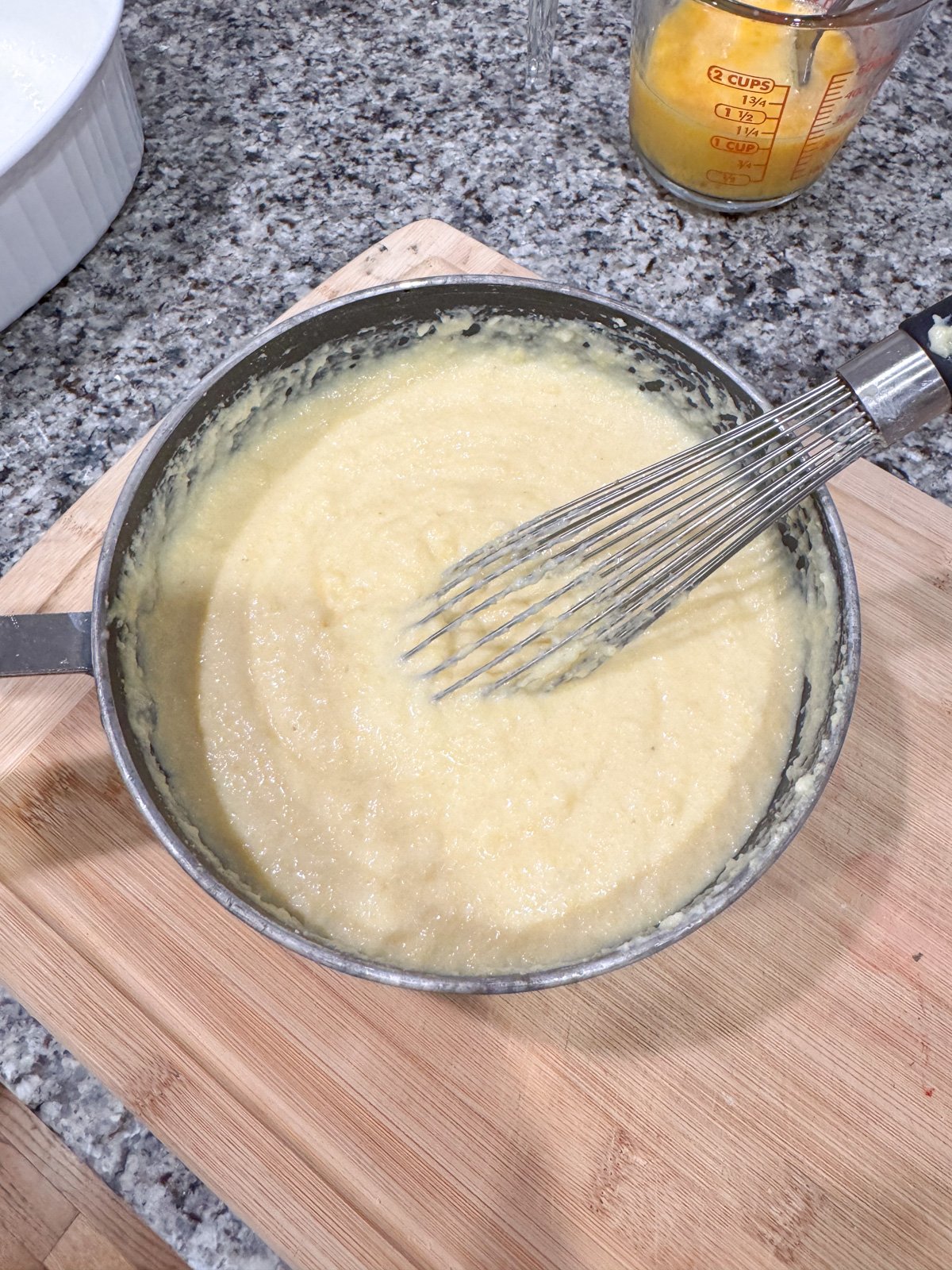 Whisking together the batter for spoon bread in a pot. 