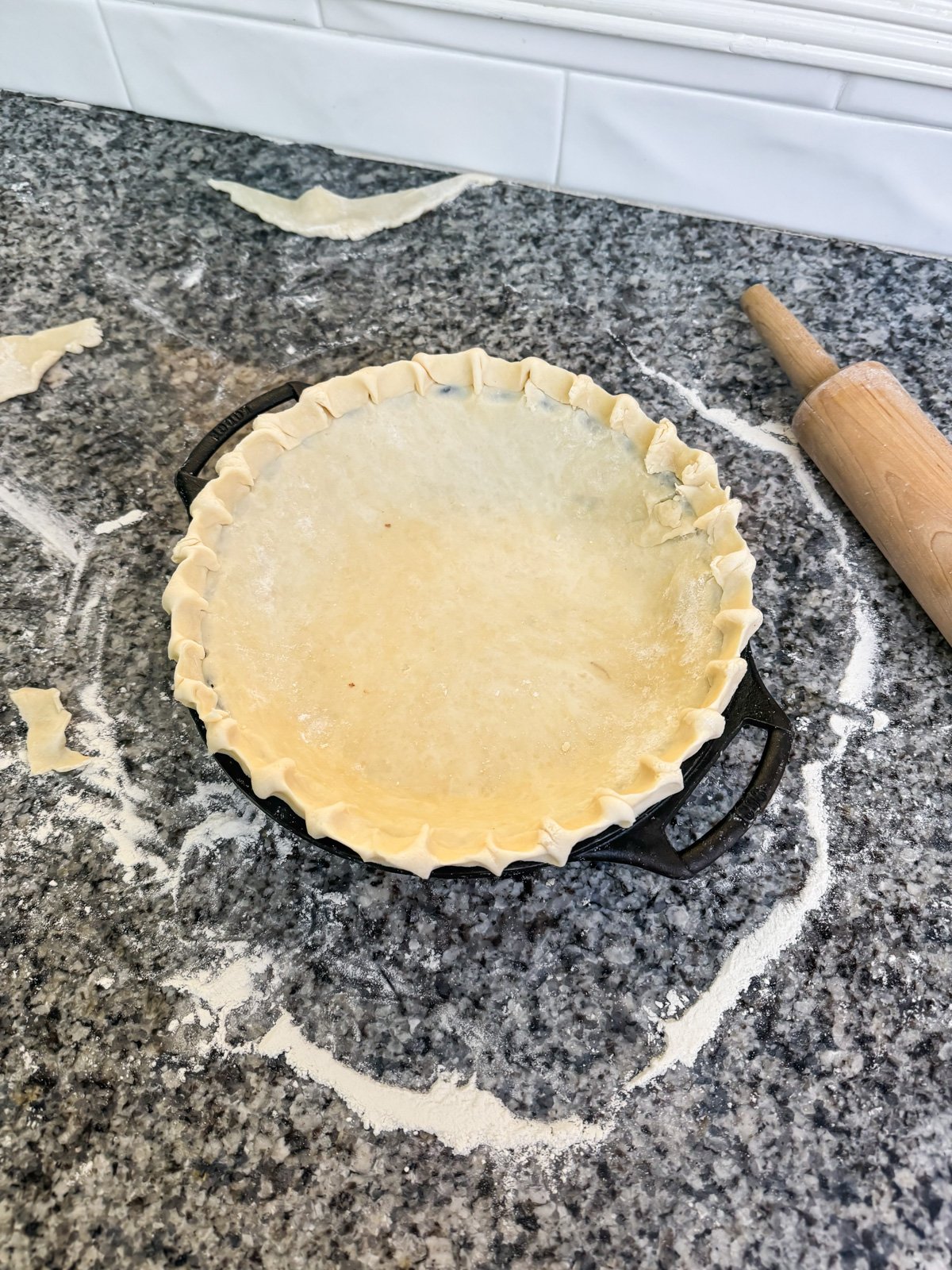 pie crust crimped and shaped in a pie plate on a kitchen counter.