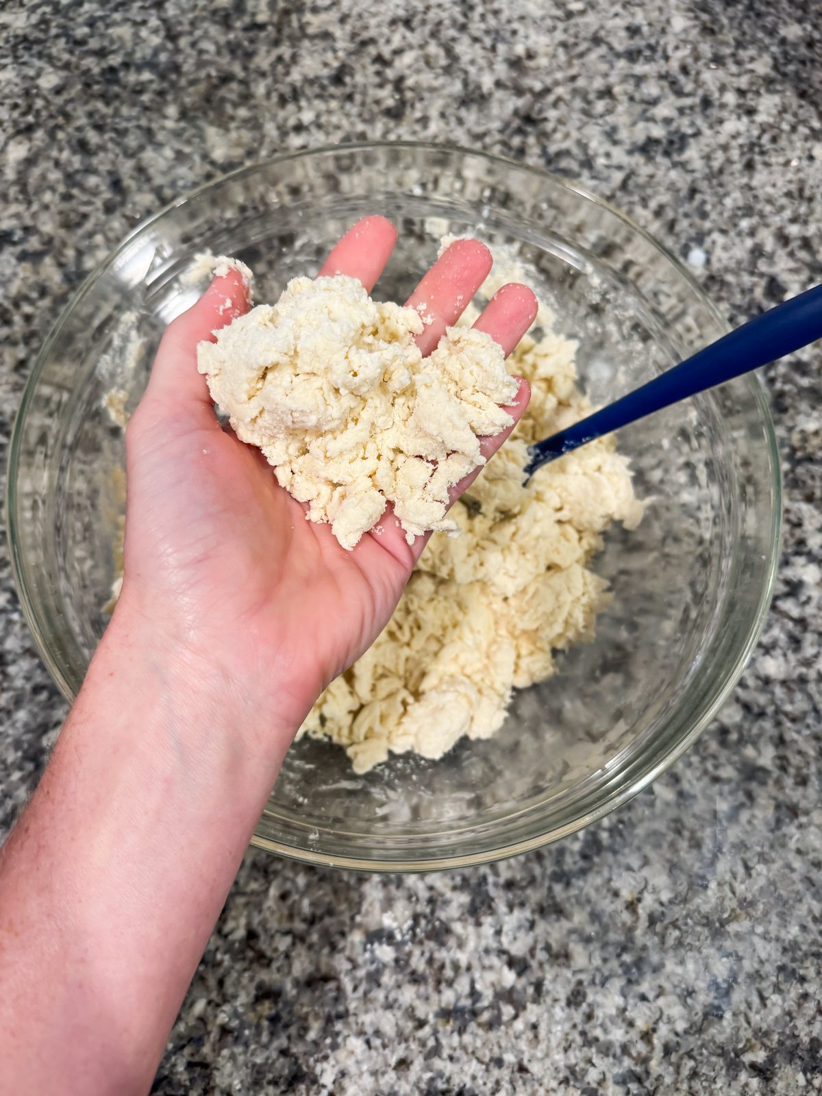 a hand holding pie crust dough. 