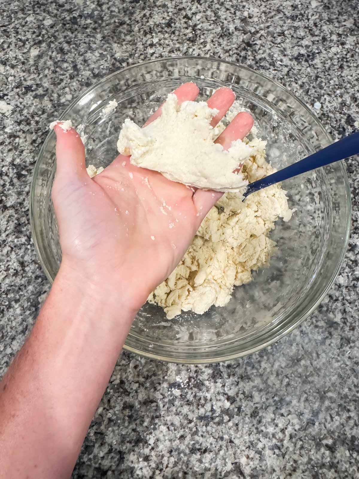 a hand holding pie crust dough. 