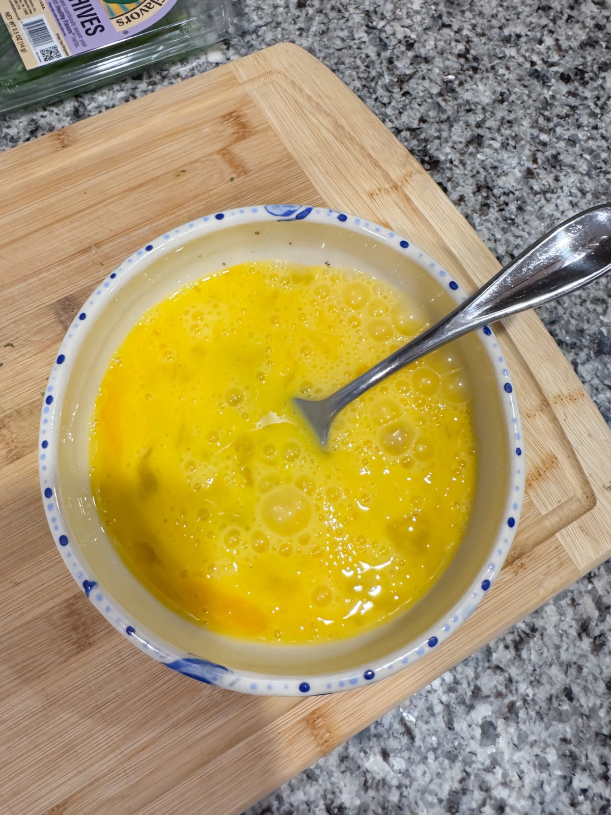 Whisking eggs in a bowl with a fork.
