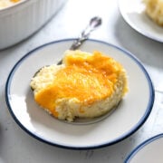 a scoop of cheddar grits casserole on a small plate